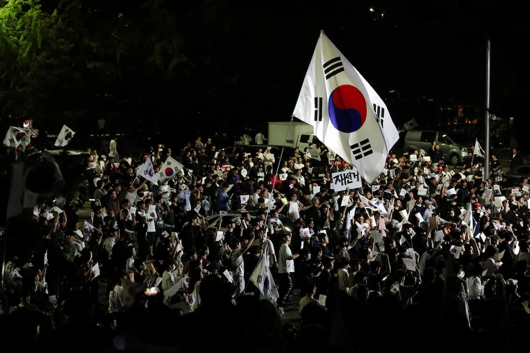야간 집회 현장 — 태극기와 손팻말을 든 참여자들