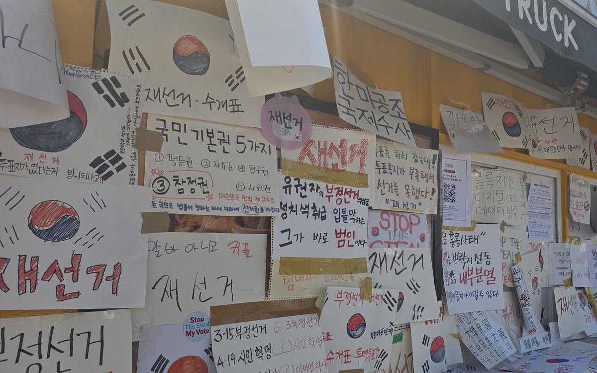 손글씨 팻말이 빼곡히 붙은 벽 — 재선거·수개표·국민 기본권을 적은 시민들의 손팻말